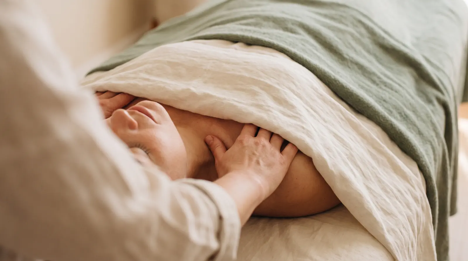 Close-up of a gentle lymphatic drainage massage technique at the neck and collarbone